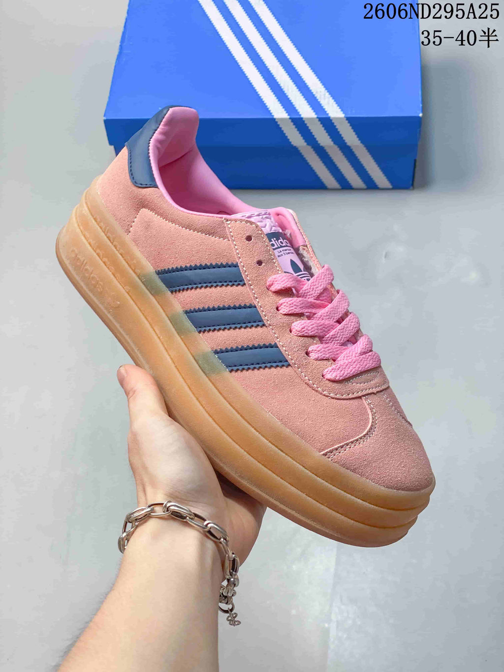 Side view of a pink sneaker with navy stripes and a gum-look platform sole