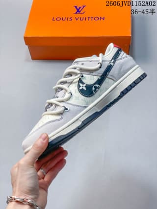 Side view of the low-top sneaker showing the white upper, dark blue patterned side panel, and contrasting outsole.