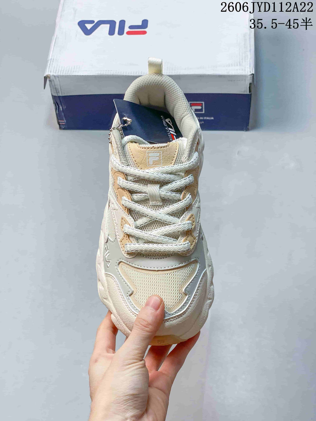 Front view highlighting the lace-up design and layered cream and beige panels.