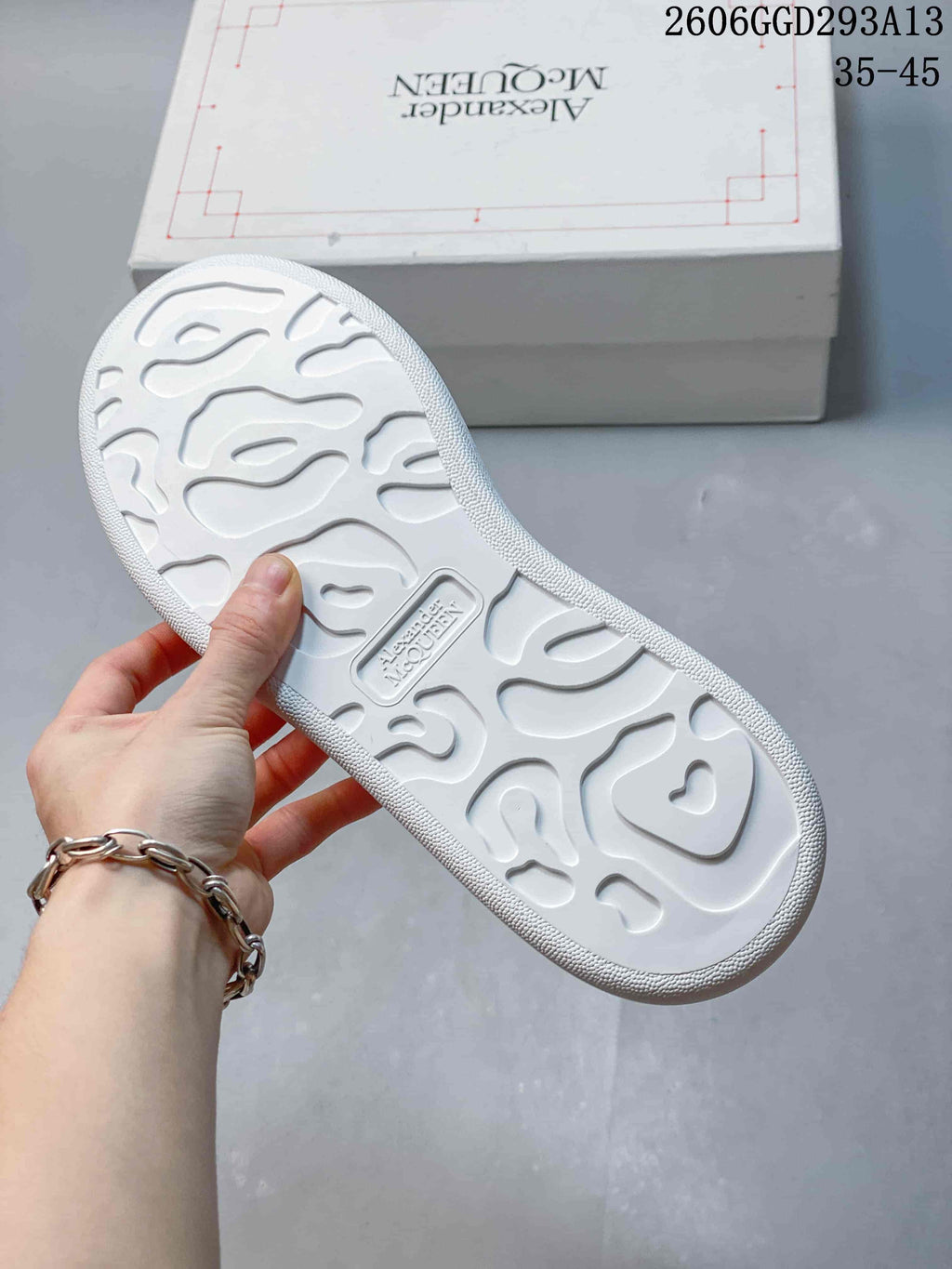 Underside of a white sneaker showing a molded sole pattern