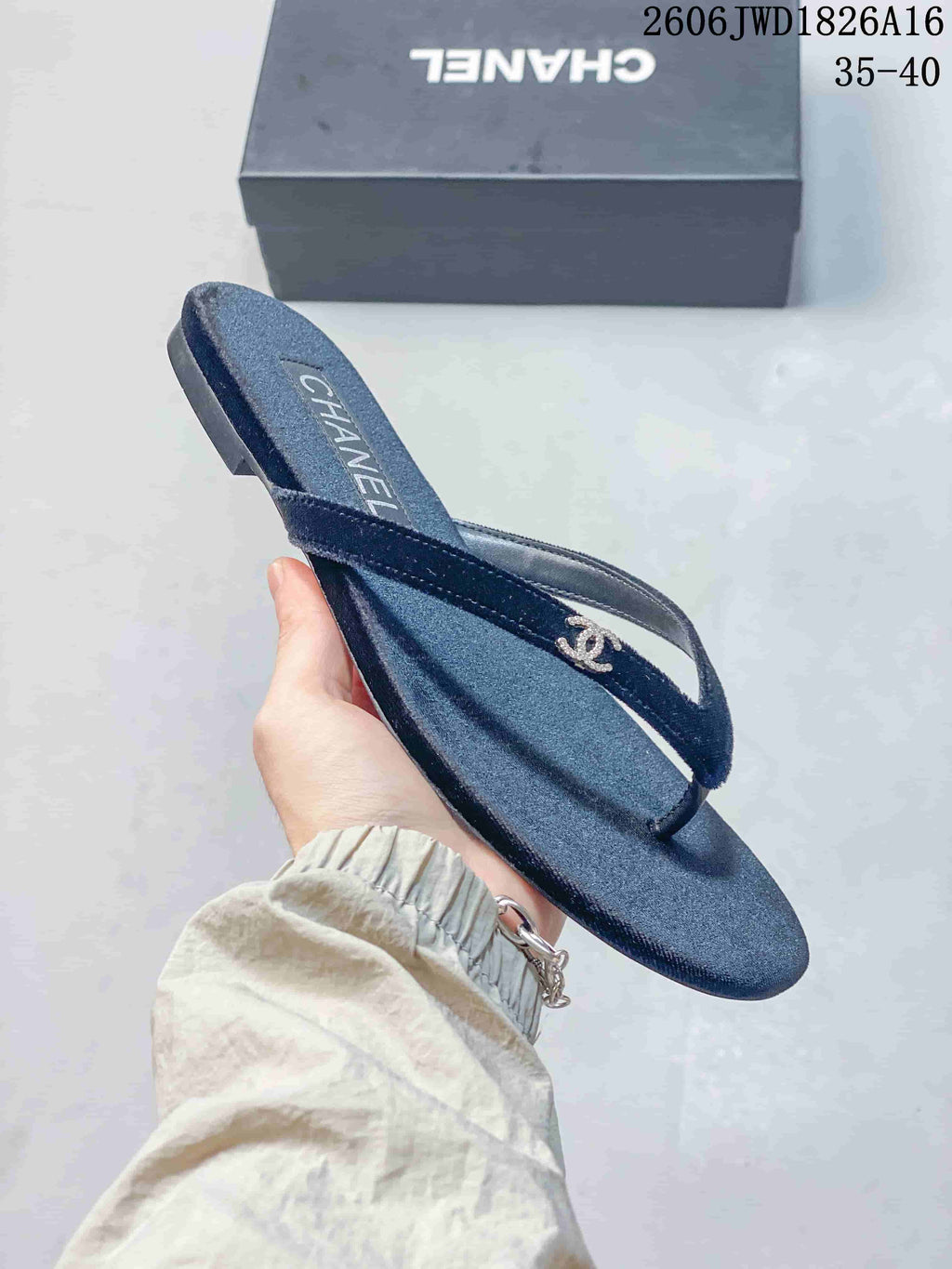 Angled view of a navy thong sandal with slim straps, textured footbed, and metallic detail.
