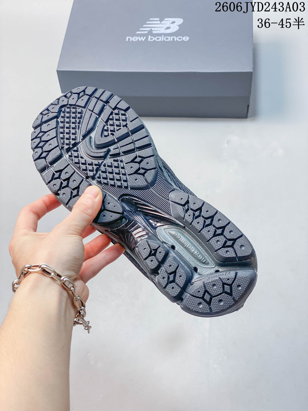Close-up of the patterned outsole on a charcoal gray New Balance 1906L shoe