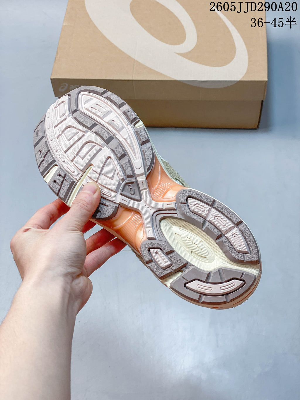 Underside of the sneaker showing a segmented patterned outsole and orange-toned midsole sections.