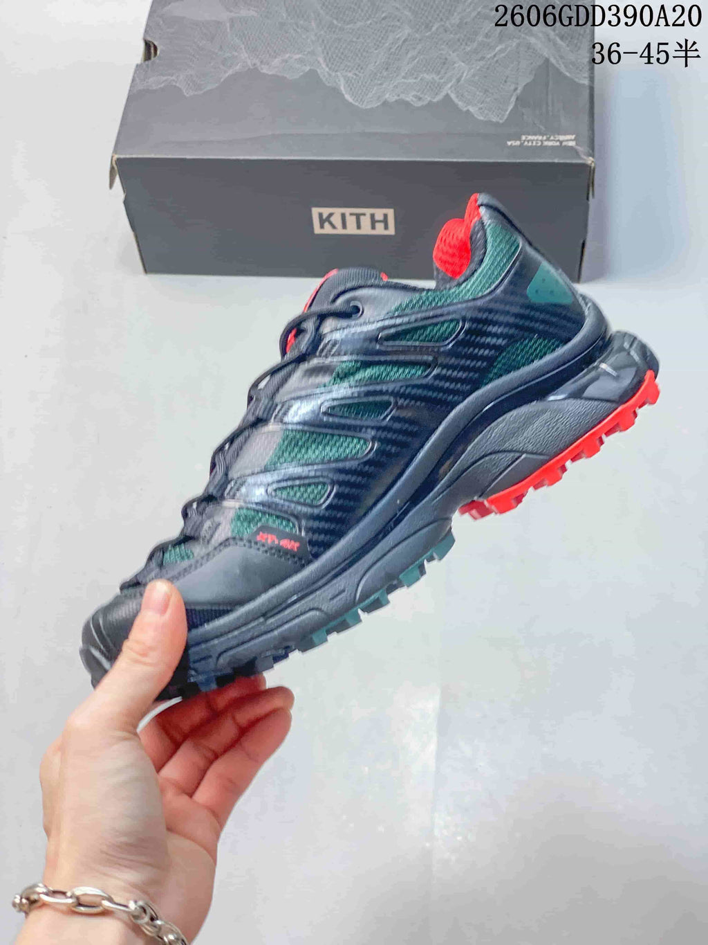 Side view of a navy and teal Salomon XT-4K trail shoe with red outsole accents.