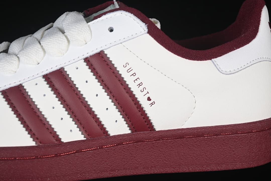Close-up of the white side panel, burgundy three stripes, and Superstar marking.