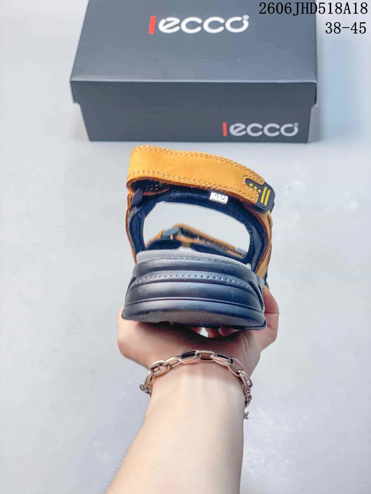 Rear view of an orange and gray sandal showing the heel strap and sole.