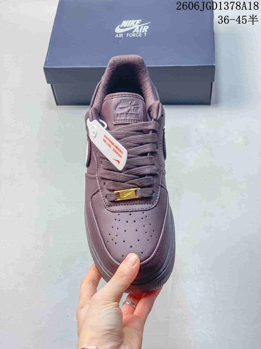 Top view of a mauve low-top sneaker with perforated toe, matching laces, and gold-tone lace detail.