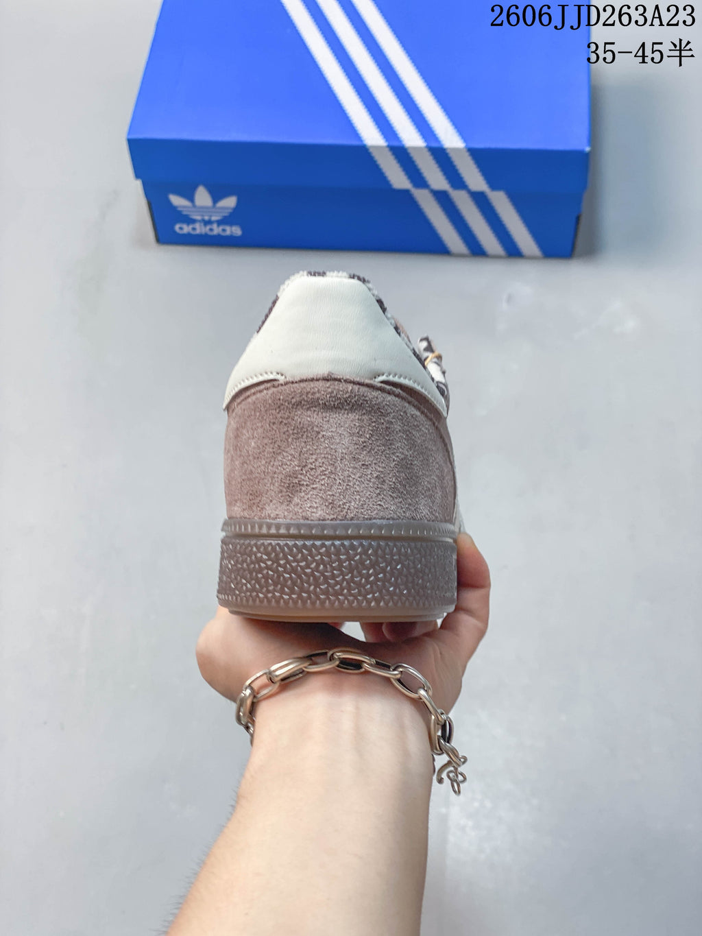 Rear view of the sneaker with a taupe heel and off-white heel tab.
