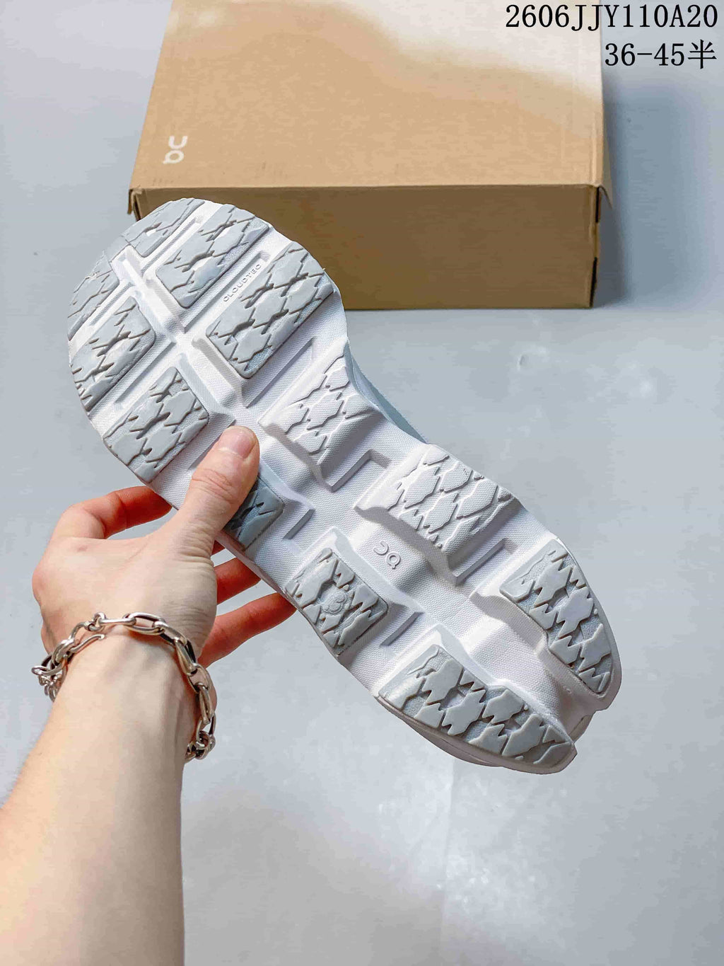 Underside of a white and gray shoe showing segmented tread; image states sizes 36–45.5.