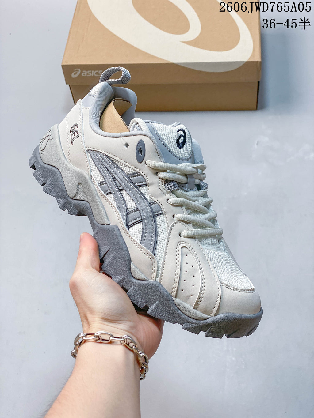 Light gray and white ASICS Gel-TRUCK sneaker shown from the side and front.