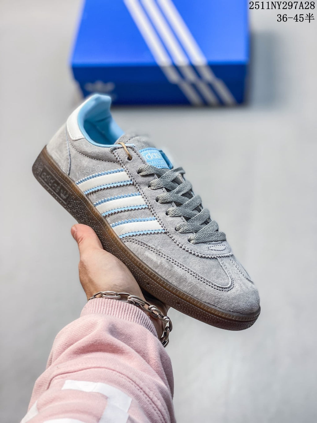 Gray Adidas Spezial-style sneaker with pale blue stripes and brown outsole