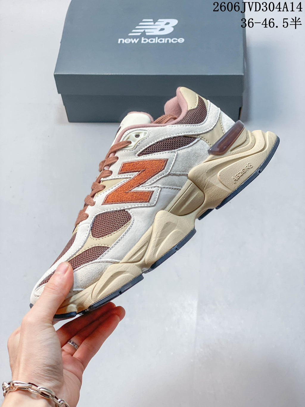 Side view of a New Balance 9060 sneaker with mesh panels and a large logo