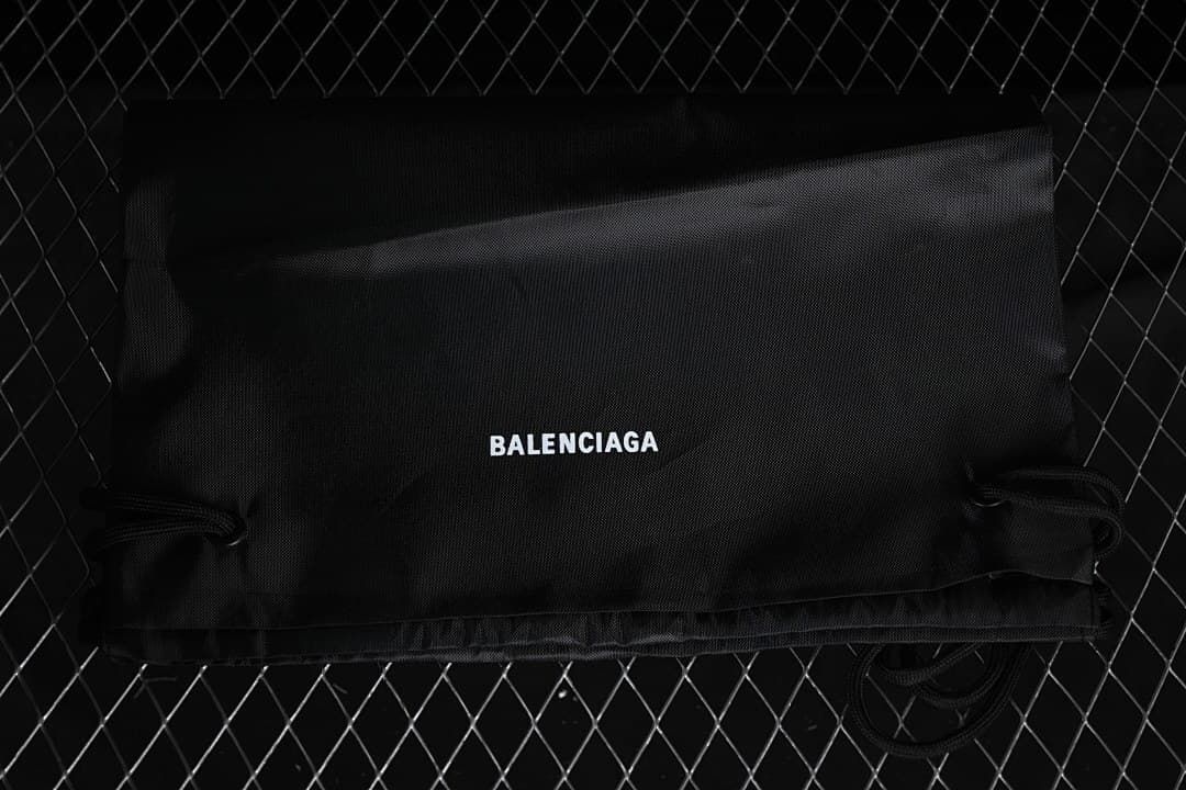 Black Balenciaga drawstring bag shown against a dark background.