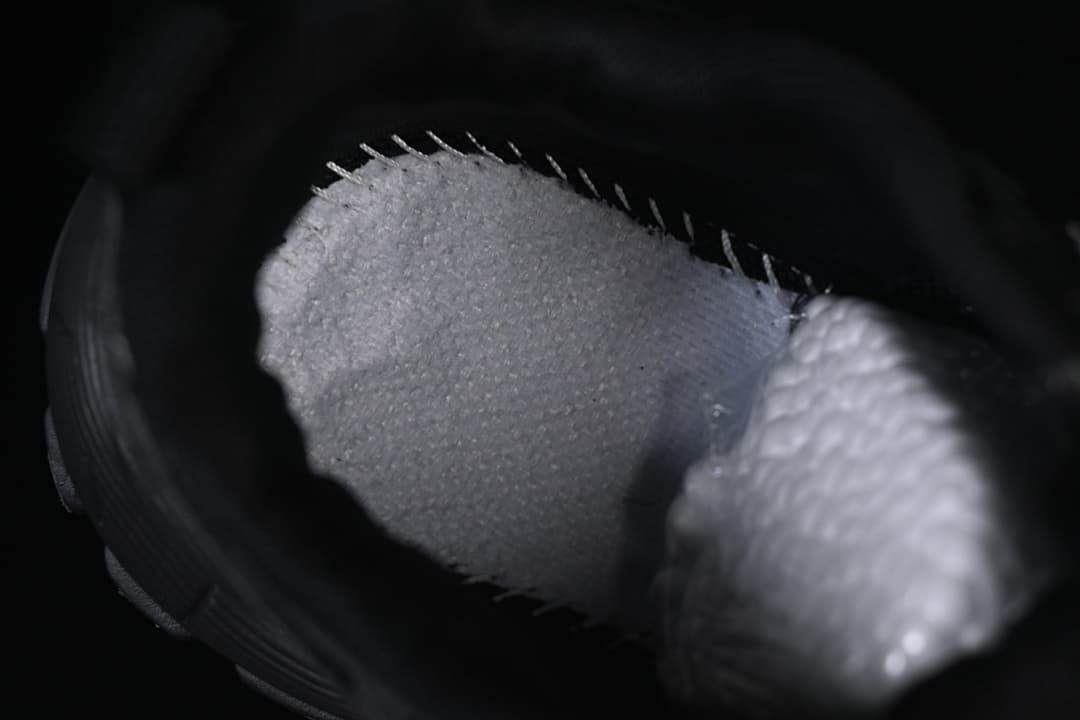 Close-up view inside the black sneaker, showing its padded collar and lining.