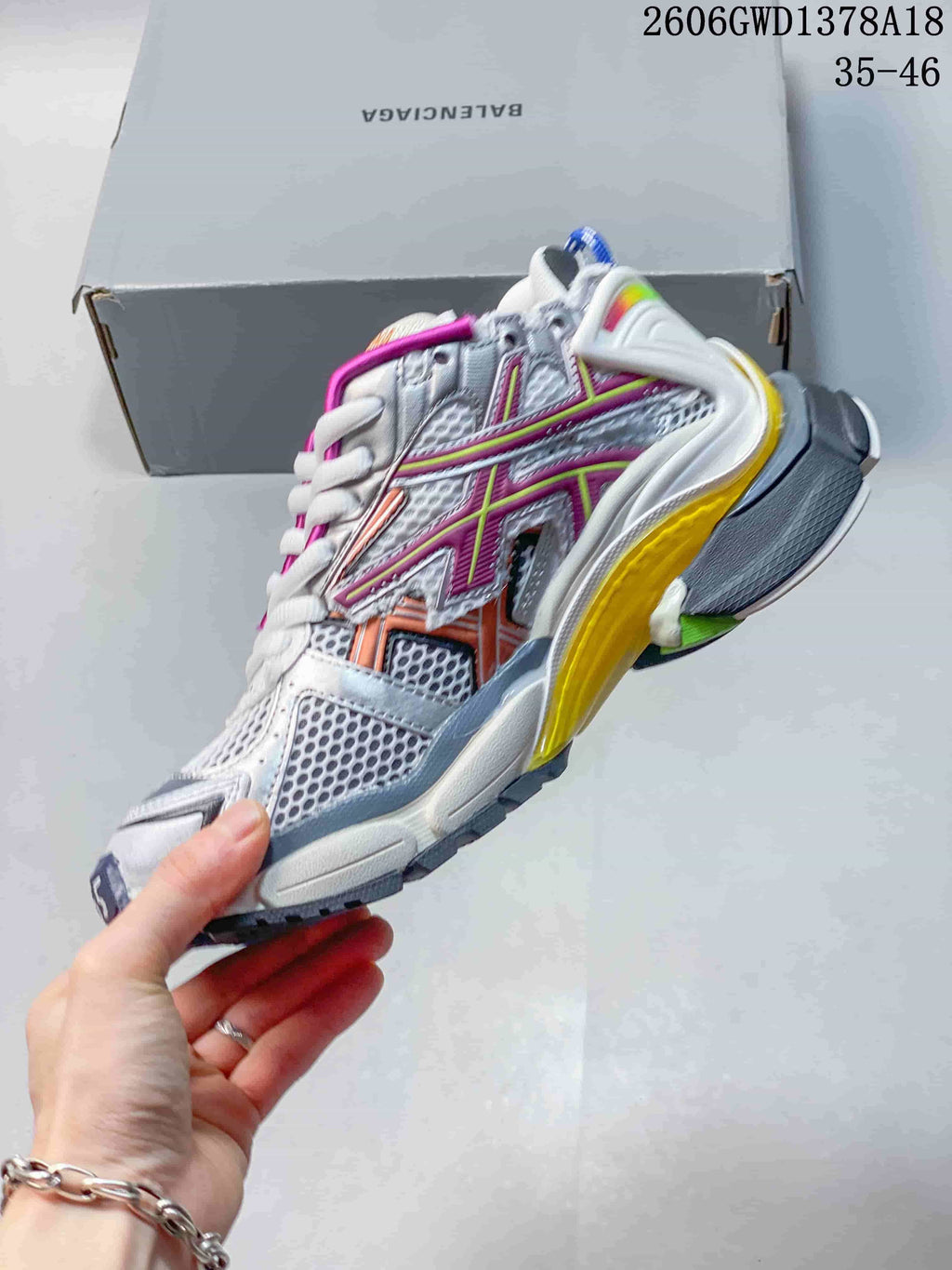 Side view of a silver and white Balenciaga Runner sneaker with magenta and orange details