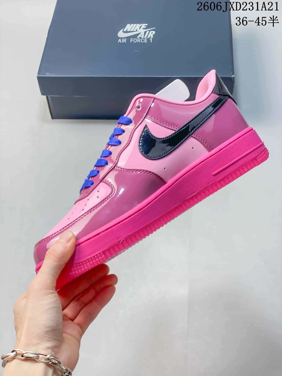 Side view of a pink Nike Air Force 1 sneaker with glossy dark Swoosh and blue laces