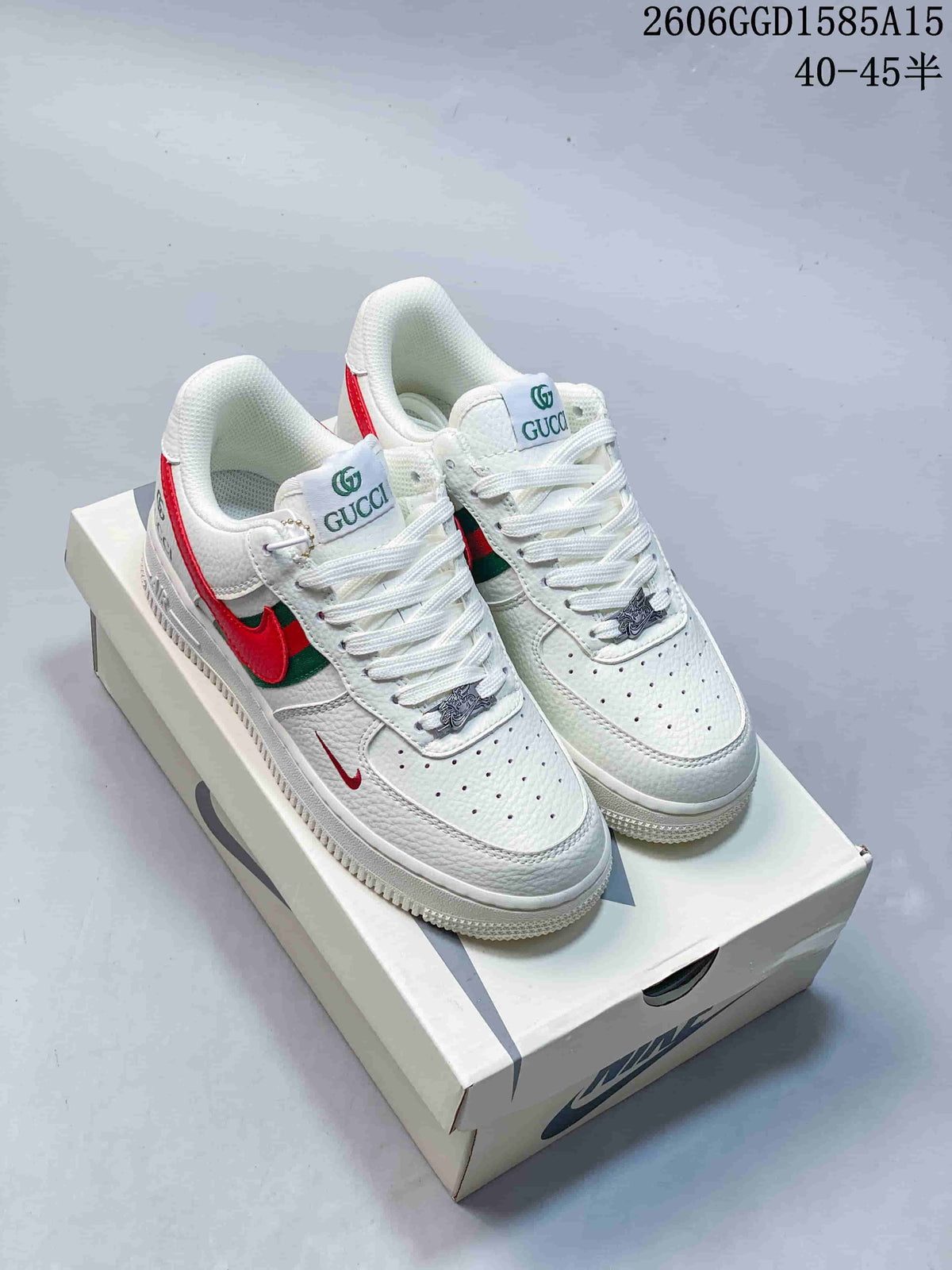 Pair of white low-top sneakers with red-and-green side panels, perforated toe panels, and decorative lace charms.