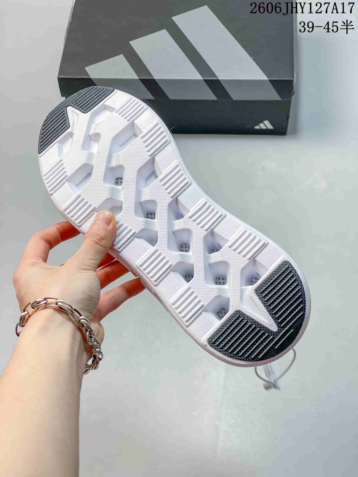 Underside of the white sneaker sole showing dark tread sections