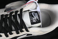 Close-up of the Nike Air Force 1 tongue, black laces, and sail-colored upper