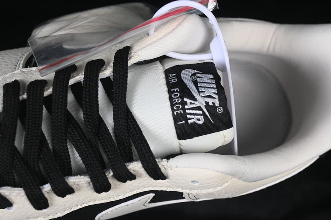 Close-up of the Nike Air Force 1 tongue, black laces, and sail-colored upper