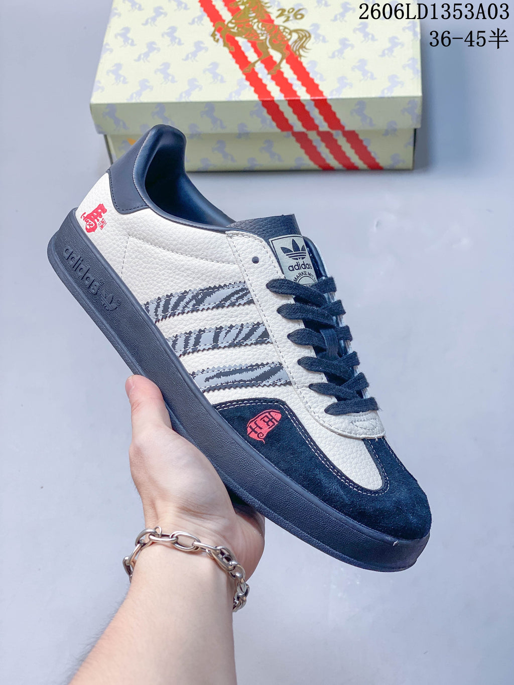 White Gazelle Indoor sneaker with navy accents, patterned stripes, and horse-themed details.