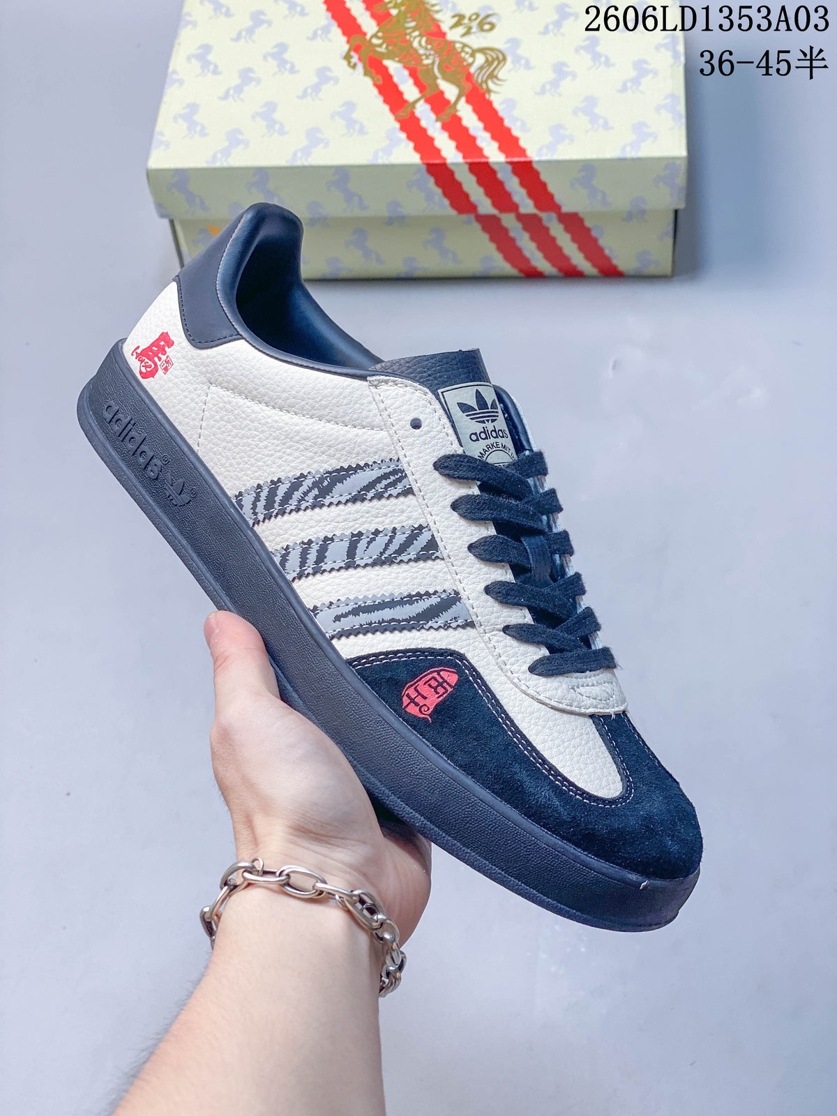 White Gazelle Indoor sneaker with navy accents, patterned stripes, and horse-themed details.