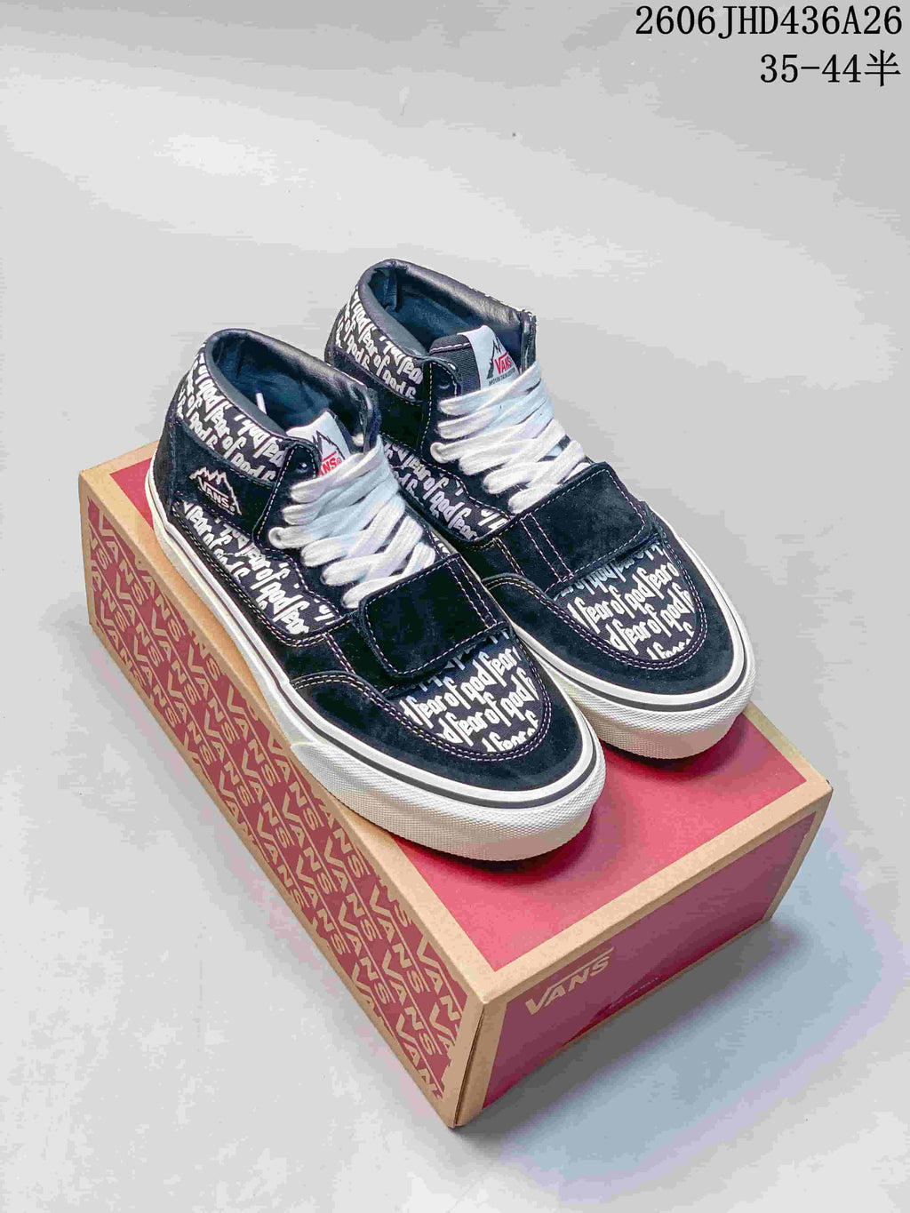 Navy Vans Era 95 Reissue-style sneakers with Fear of God name print, white laces and a forefoot strap, displayed on a Vans box.