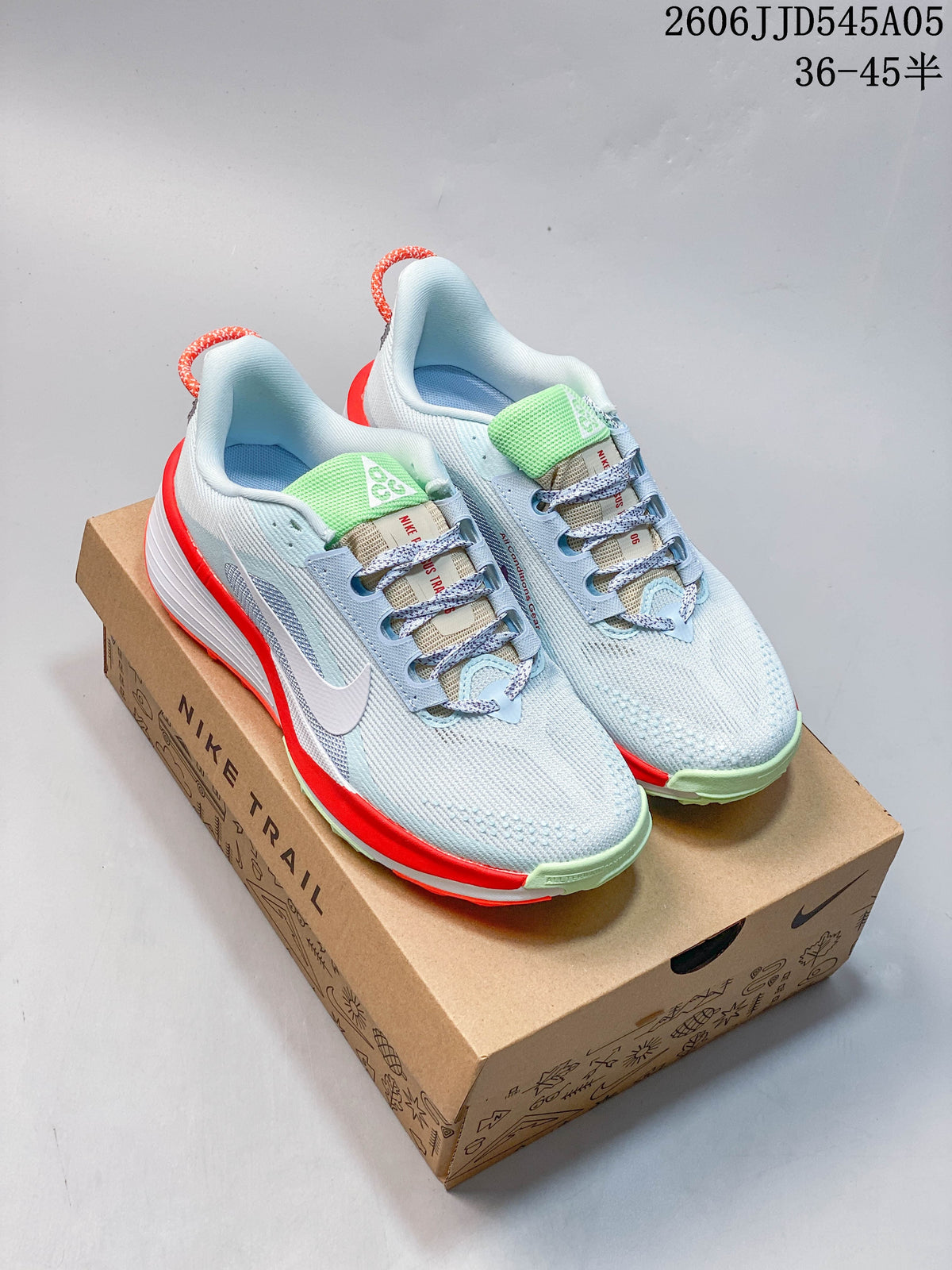 Pair of light blue Nike Pegasus Trail 6 shoes on a box, showing bright red-orange and pale green accents.