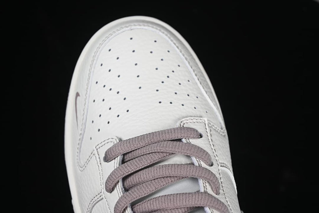 Top-down detail of perforated toe box and mauve laces