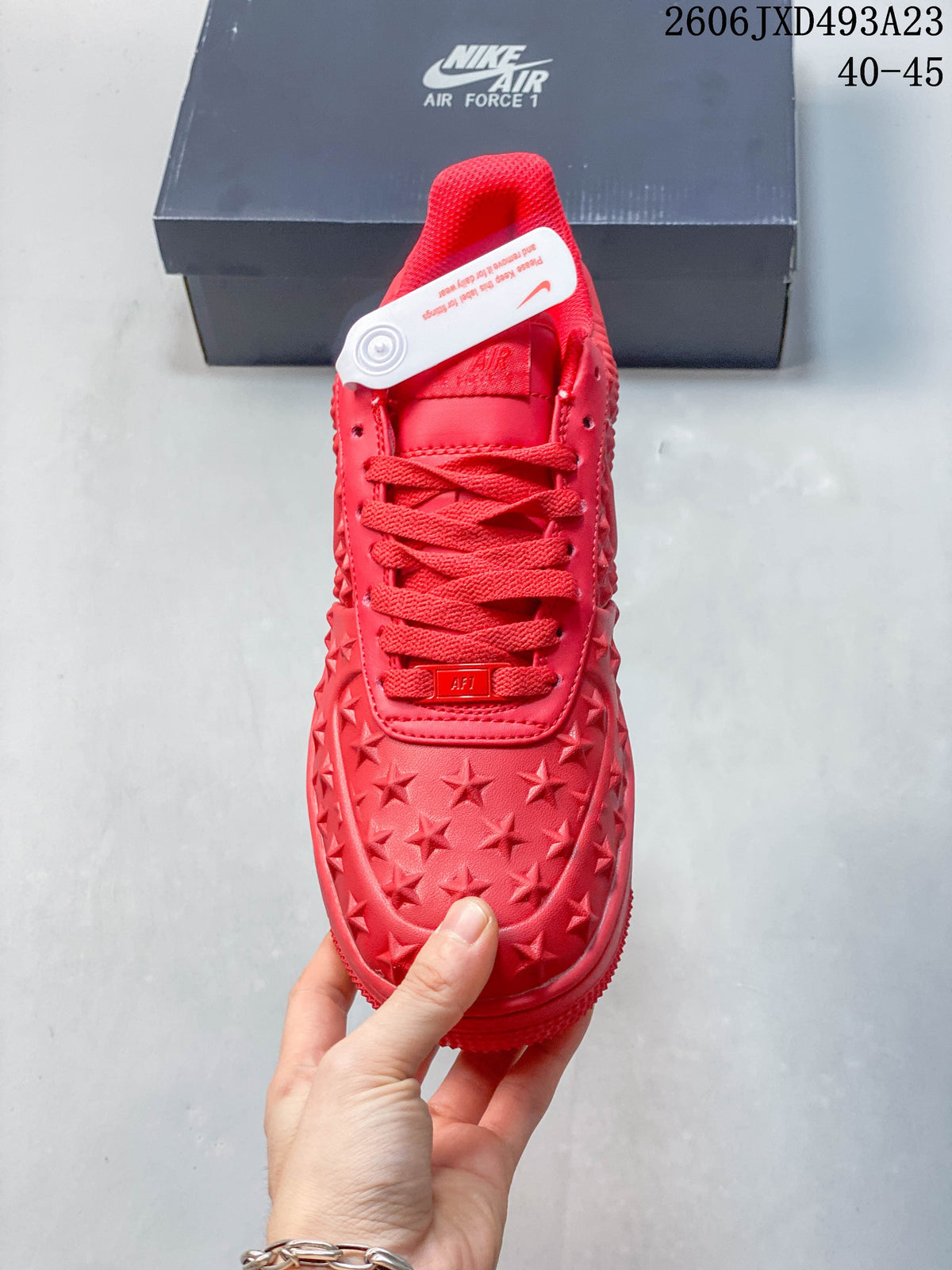Top view of a red lace-up sneaker with raised star detailing across the toe