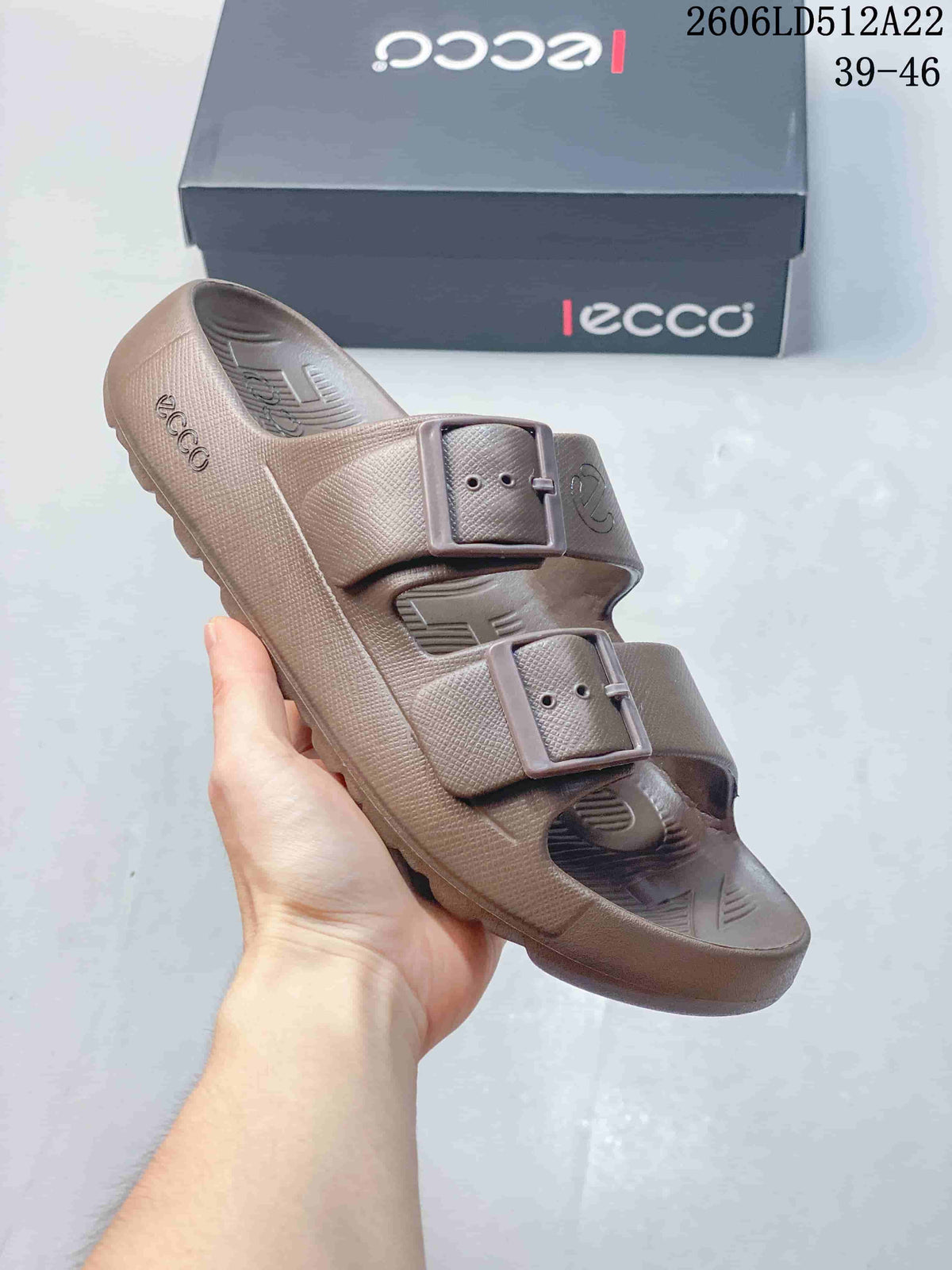 Angled view of the taupe sandal showing its buckle straps and sole.