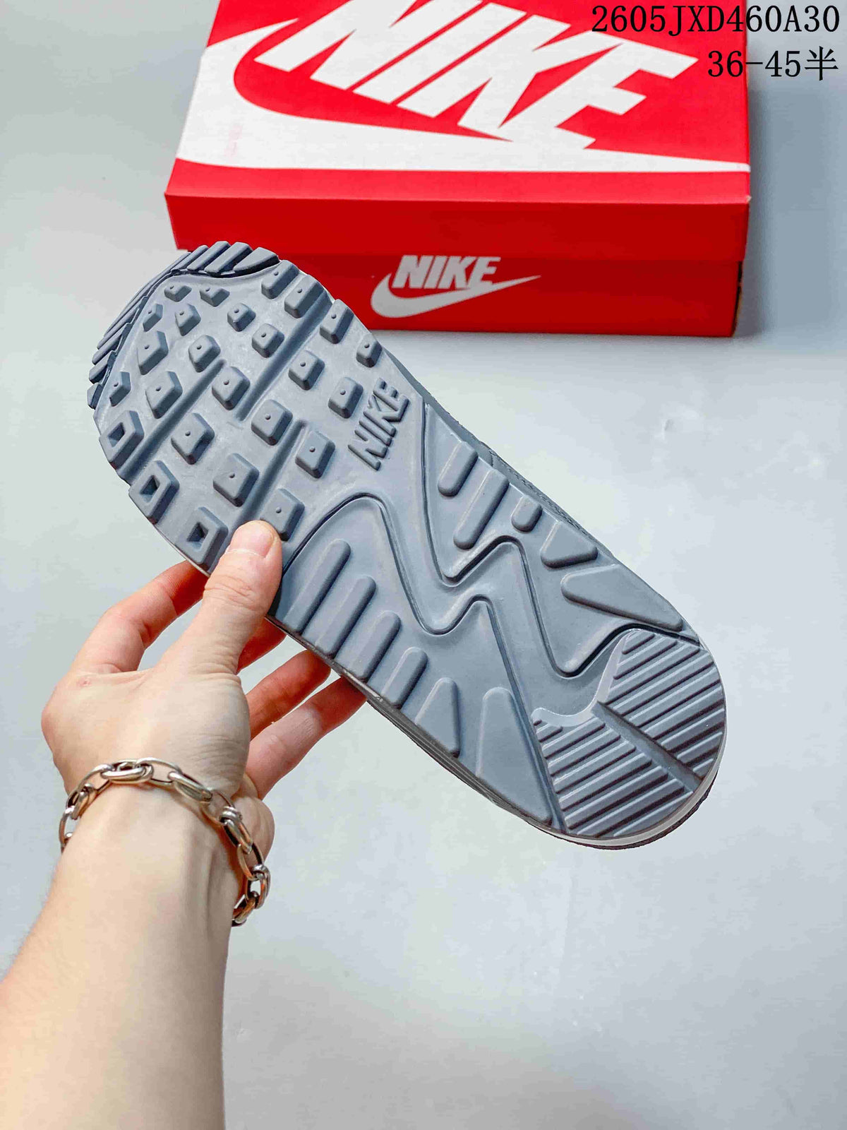 Close-up of the grey Nike Air Max 90 outsole showing raised tread