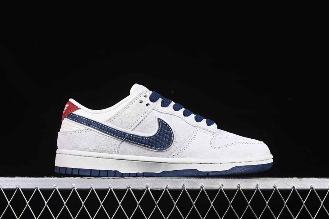 Side profile of the white low-top sneaker with a navy patterned swoosh