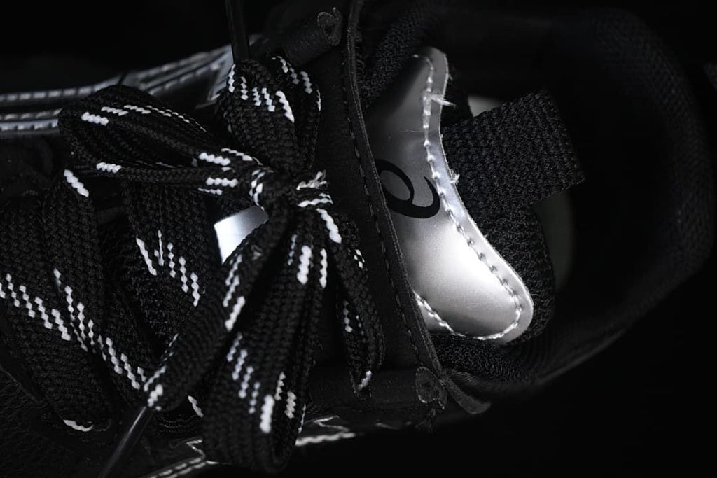 Close-up of the patterned black-and-white laces and silver tongue detail.