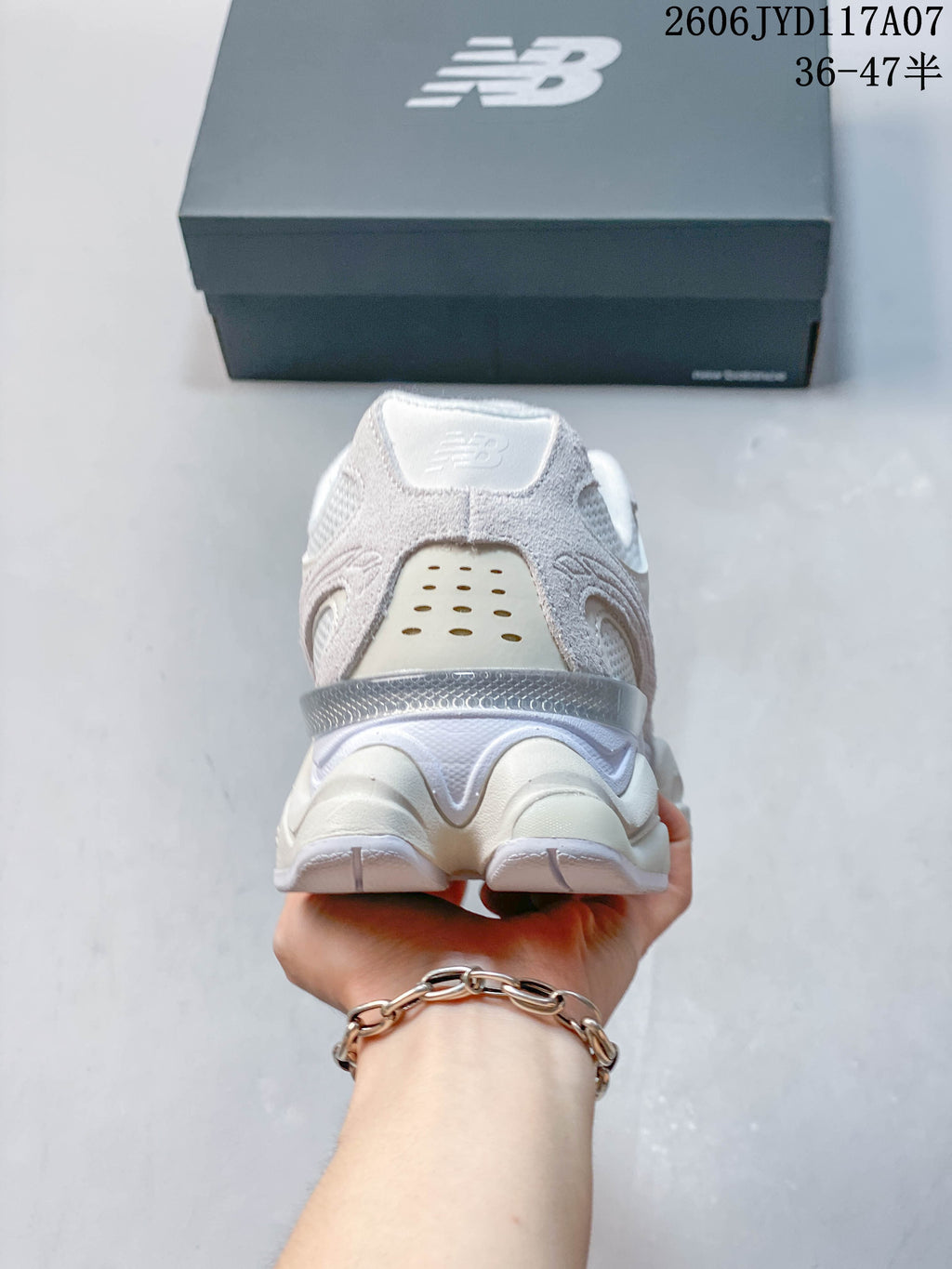 Rear view of a white and pale grey New Balance 9060 sneaker