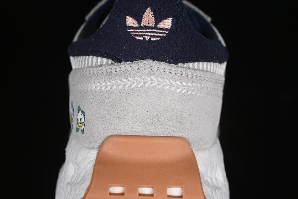 Rear view of the sneaker with navy heel detail, character graphic, and gum-colored heel piece