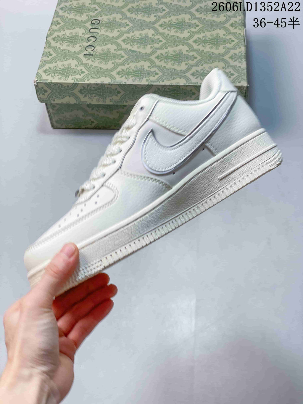 Side profile of the white Nike low-top sneaker with a pale gray Swoosh and textured outsole.