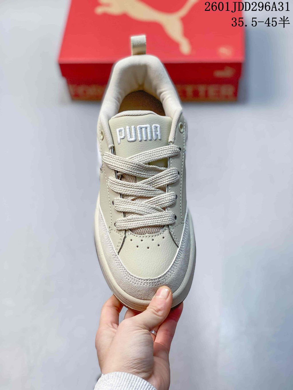 Top view of a cream PUMA sneaker with laces and tongue branding