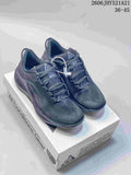 Pair of dark gray Nike ACG lace-up shoes on a box, shown from the front and side.