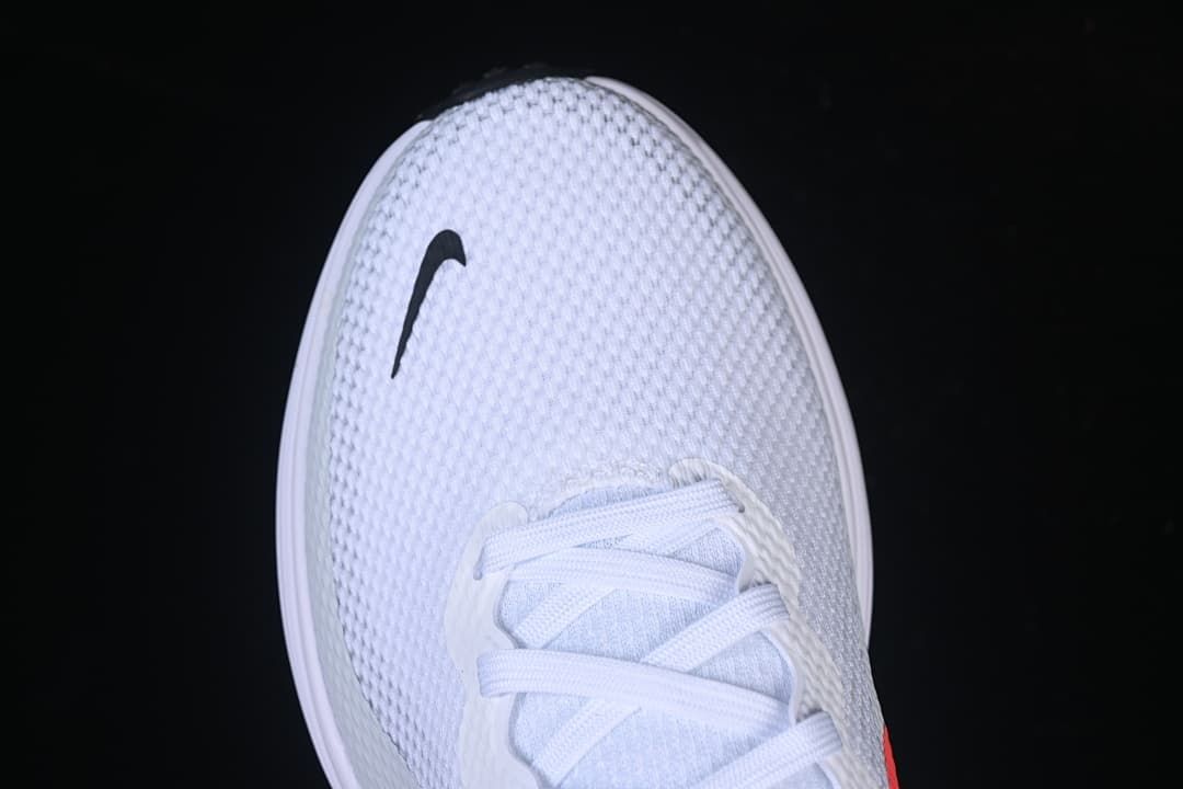 Top view of the textured white toe with a small black Swoosh
