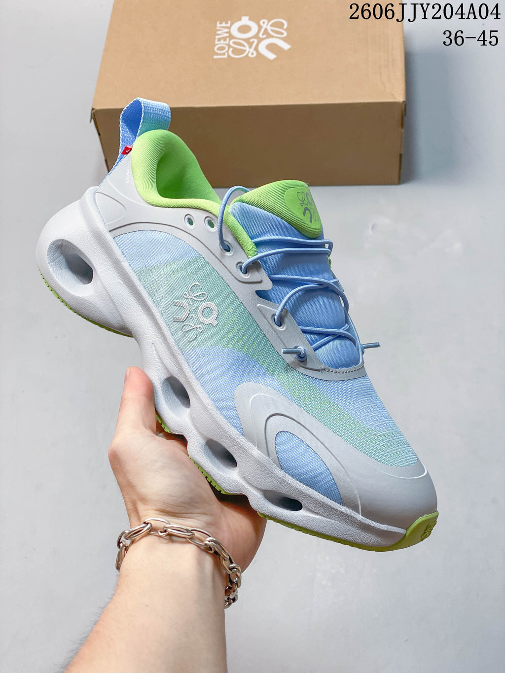Side view of a light blue and pale green sneaker with a sculpted white sole and blue heel pull tab.
