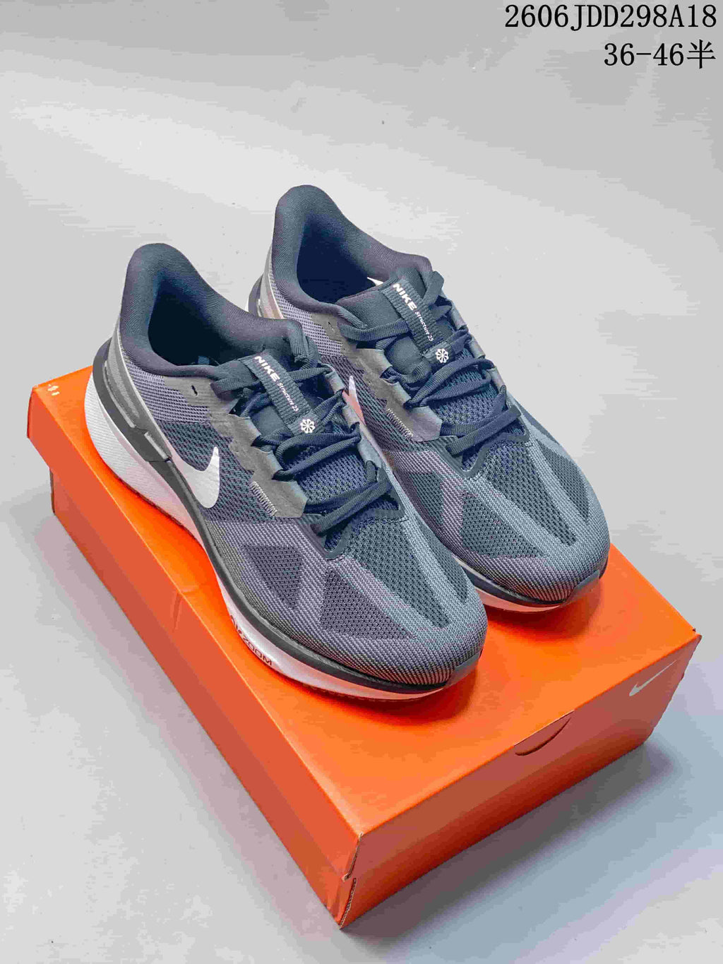 Pair of gray Nike Structure 25 running shoes on an orange shoebox