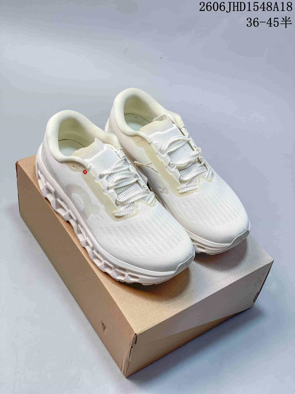 Pair of white On Cloudmonster sneakers displayed on a shoebox
