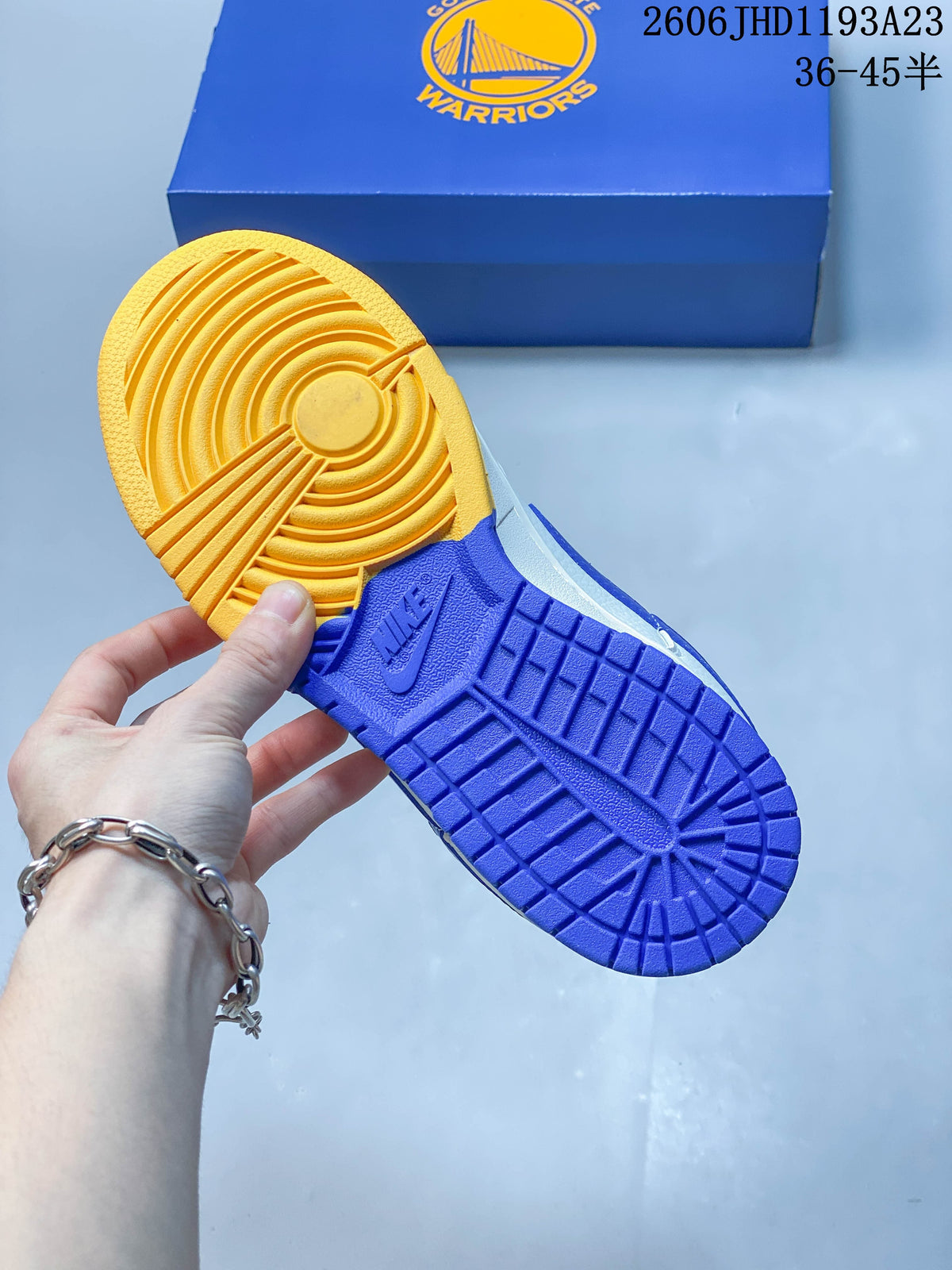 View of the sneakers’ blue and yellow outsole beside a Golden State Warriors box