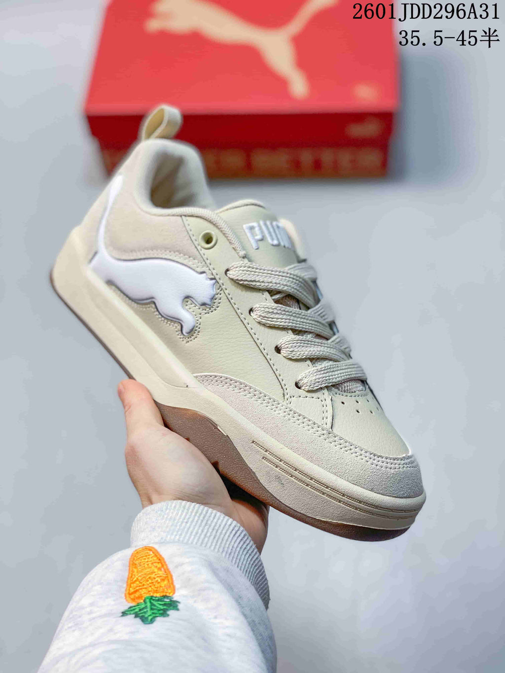 Angled side view of a cream and white PUMA 180 sneaker