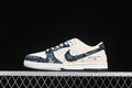 Side view of a cream and dark blue denim-style Nike SB Dunk Low sneaker with patterned panels.