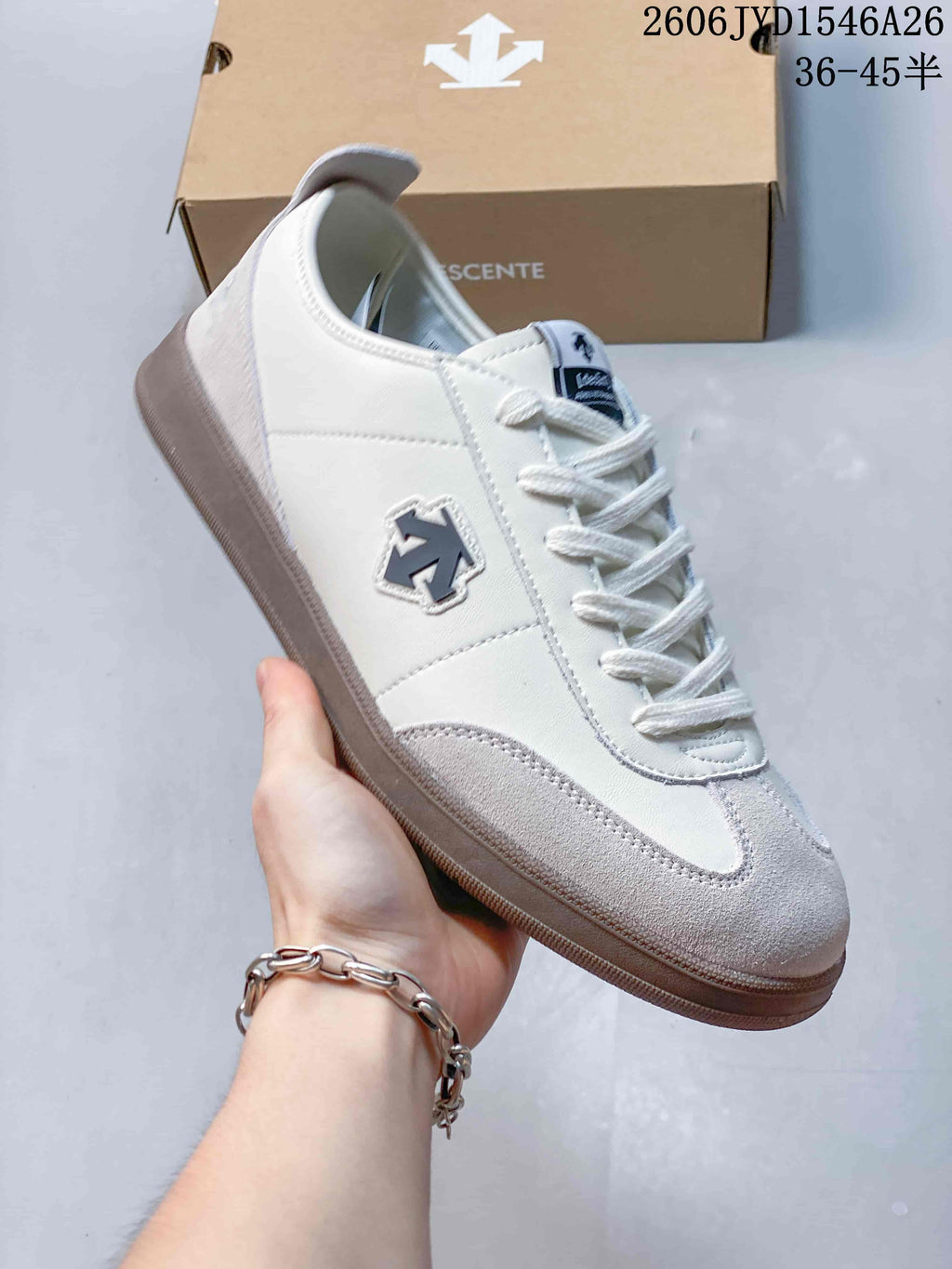 Side view of a white and light gray Descente low-top sneaker.