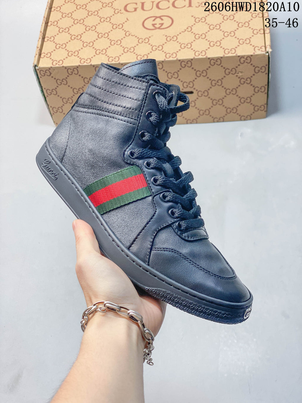 Close side view of a dark gray high-top sneaker with a green-and-red stripe and lace-up front.