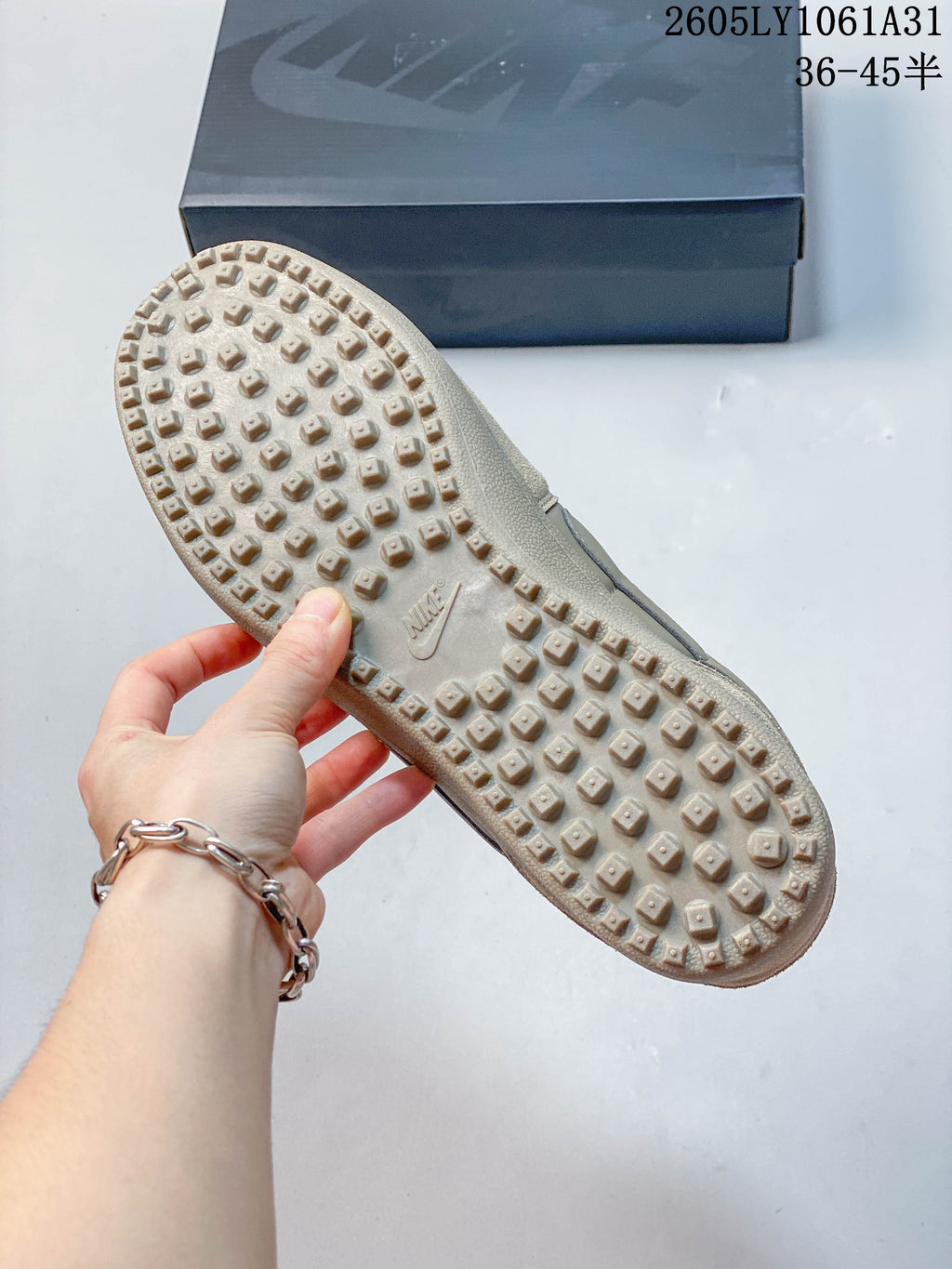 Close-up of the raised tread pattern on the taupe sneaker outsole