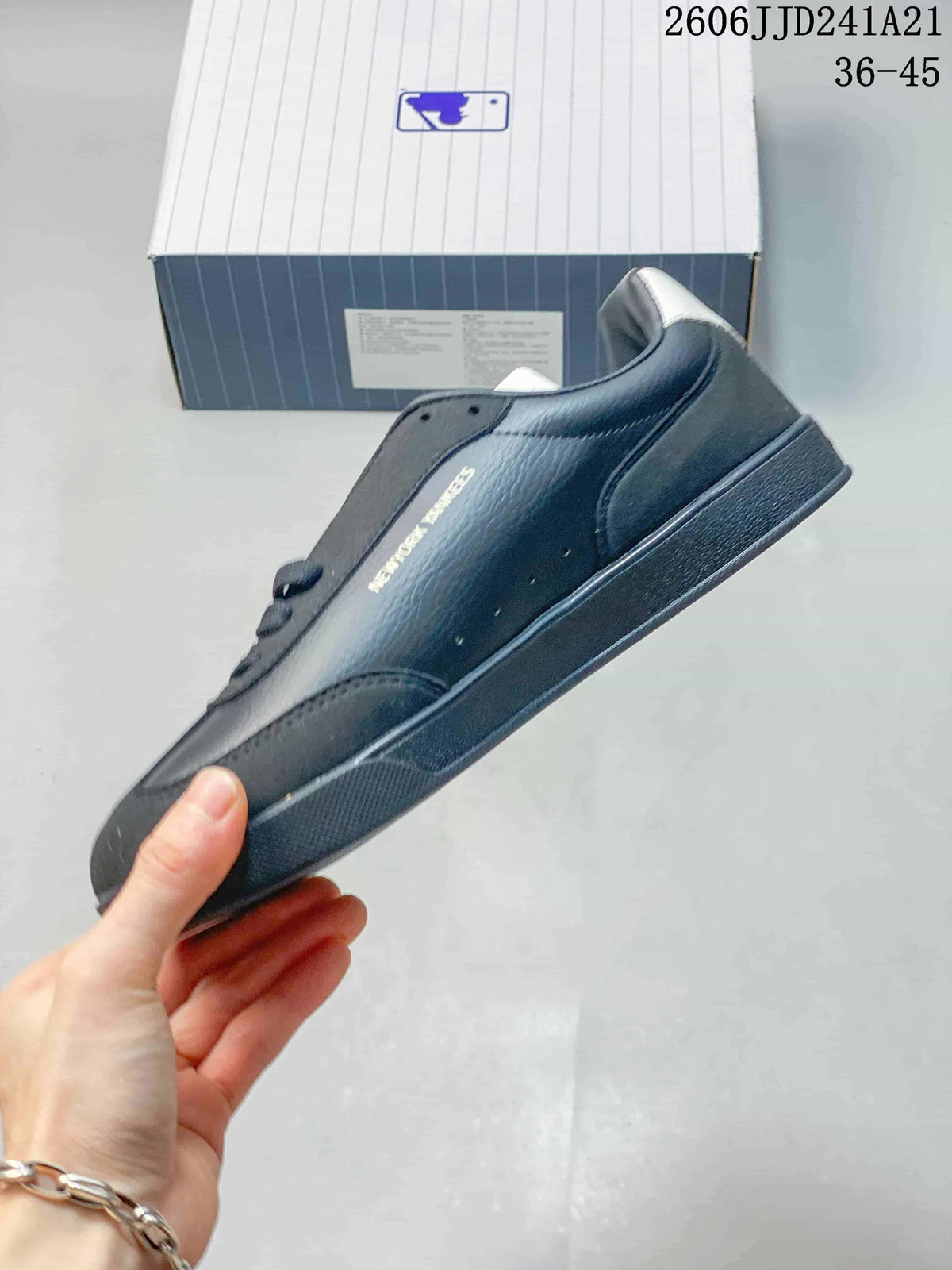 Side profile of a dark navy low-top sneaker with Yankees text detail